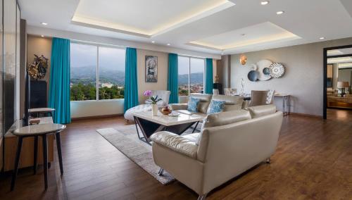 a living room with a couch and a table at Grand Sunshine Resort & Convention in Bandung