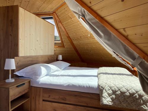 a bedroom with a bed in a wooden cabin at DalaiLama Village in Antey-Saint-André