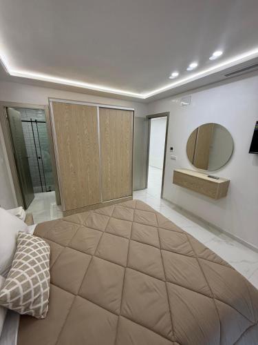 a bedroom with a large bed and a large mirror at Appart Résidence Sabrin in Fnidek