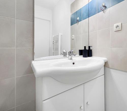 a white bathroom with a sink and a mirror at Appartement Aux Portes de Toulouse in Plaisance-du-Touch