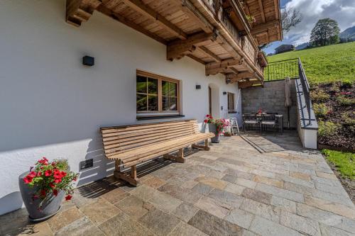 a wooden bench sitting outside of a house at Waltenberghof in Kitzbühel