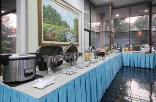 a buffet line with food on it in a restaurant at Hotel Grand Trisula Indramayu in Indramayu
