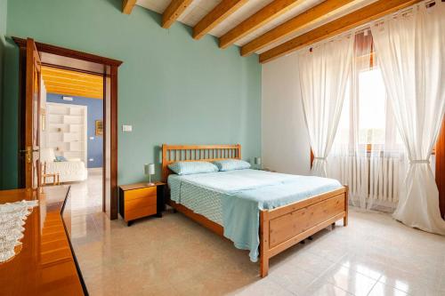 a bedroom with a bed and a large window at Redlands House - casa vacanze in Uggiano la Chiesa