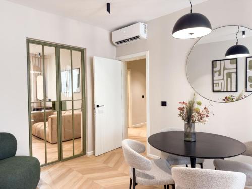 a dining room with a table and chairs and a mirror at Historic Business Loft in Iaşi