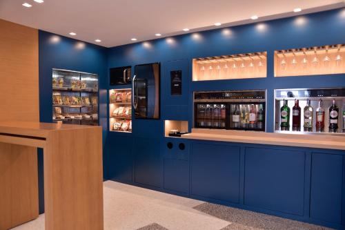 a blue room with a bar with bottles of alcohol at Hi Hotel Bari in Bari