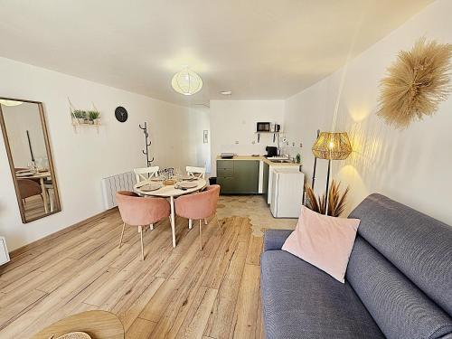 ein Wohnzimmer mit Sofa und Tisch in der Unterkunft Maison de ville Chaleureuse au cœur de Chartres Netflix, garage vélos in Chartres
