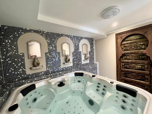 a bath tub in a bathroom with black tiles at La Casa dei Sogni in Flayosc
