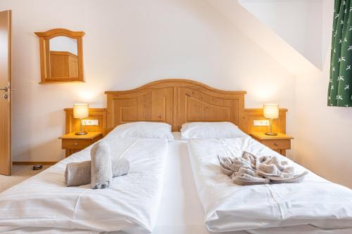 a bedroom with a bed with white sheets and towels at Apparthaus Sonnenberg in Haus im Ennstal
