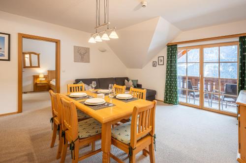 a dining room and living room with a table and chairs at Apparthaus Sonnenberg in Haus im Ennstal