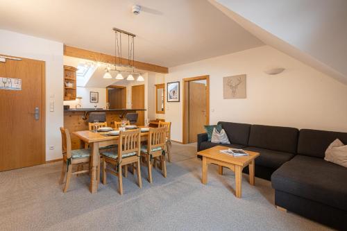 a living room with a table and a couch at Apparthaus Sonnenberg in Haus im Ennstal