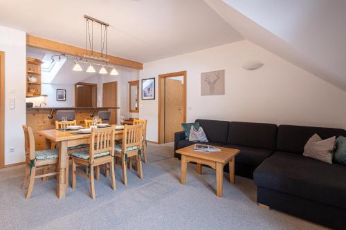 a living room with a black couch and a table at Apparthaus Sonnenberg in Haus im Ennstal
