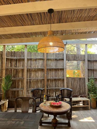 a patio with a table and chairs and a chandelier at Beit Oren Hotel in Bet Oren