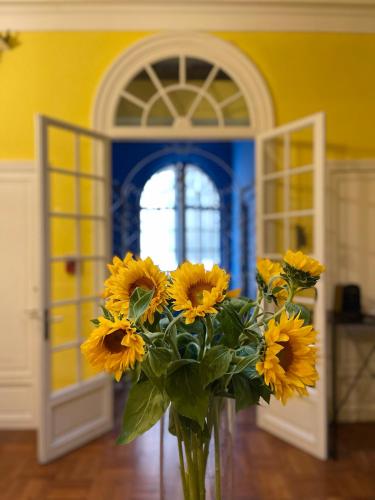 a vase filled with yellow flowers in a room at Maison Dormoy in Marseille
