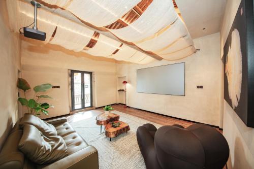 a living room with a couch and a flat screen tv at 湄洲岛泊澜清风民宿 in Putian