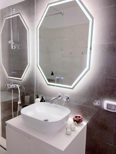 a bathroom with a sink and a large mirror at Herăstrău WIN Résidence No 4 in Bucharest