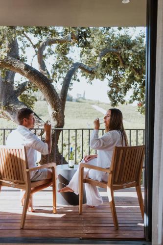 a man and woman sitting on a porch drinking wine at Laborie Estate in Paarl