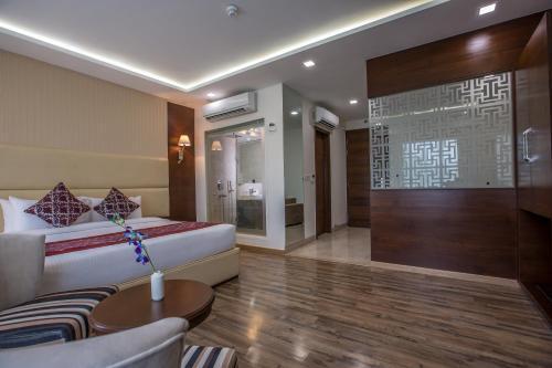 a hotel room with a bed and a couch at Clarks Inn Suites Gwalior in Gwalior