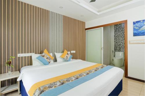 a bedroom with a large white bed with colorful pillows at h78 Iru in Hulhumale