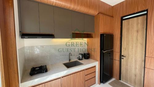 a green guest house kitchen with a sink at Green Guest House Malang in Kasri