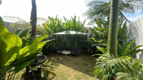 a garden with a table and an umbrella at Green Guest House Malang in Kasri