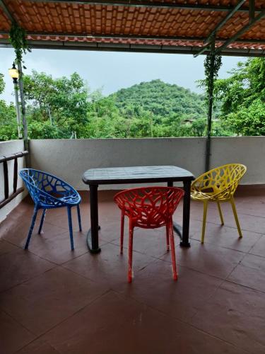 three chairs and a table on a porch at AM2PM Private Pool Villa in Badlapur