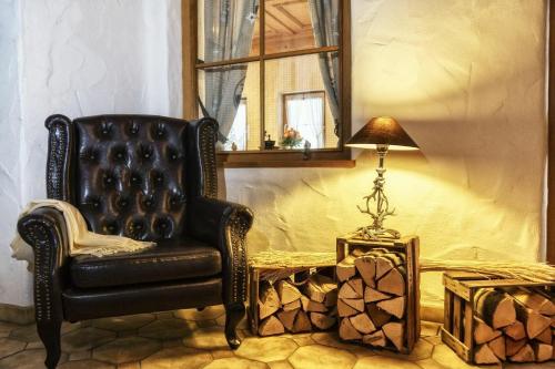 a black chair and a lamp in a room at Hotel Edelsberg in Untergschwend