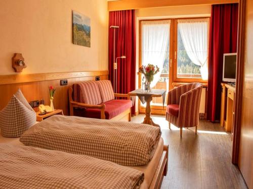 a hotel room with two beds and a television at Hotel Edelsberg in Untergschwend