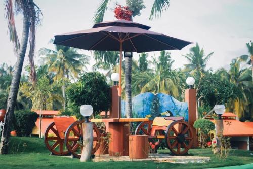 a table with an umbrella and a horse drawn carriage at Galaxy Villa room in Dalaguete