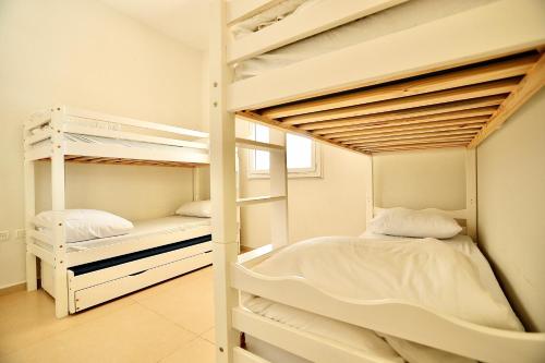 a bedroom with two bunk beds in a room at פרדייז ריזורט in Had Nes