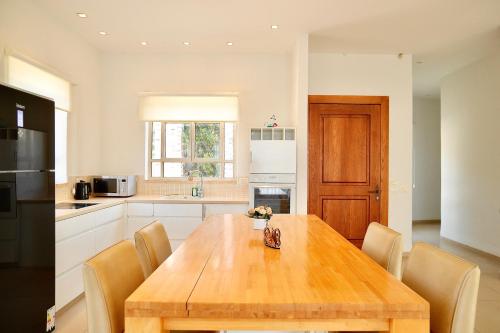 a kitchen with a wooden table and chairs at פרדייז ריזורט in Had Nes