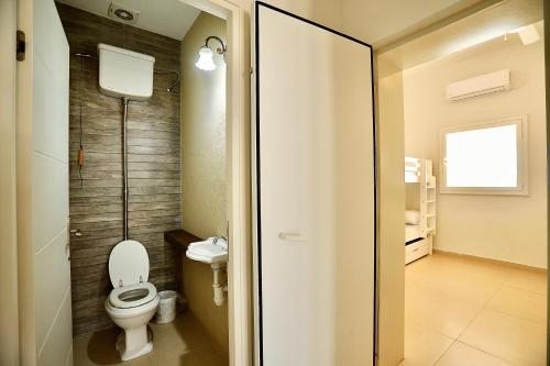 a bathroom with a toilet and a sink at פרדייז ריזורט in Had Nes