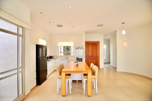 a kitchen and dining room with a wooden table and chairs at פרדייז ריזורט in Had Nes