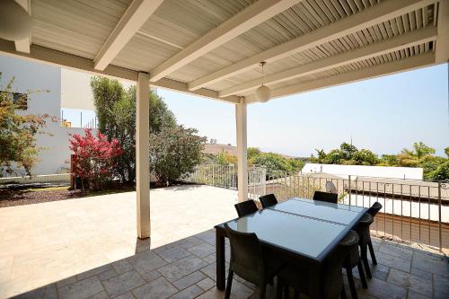 a patio with a table and chairs under a pergola at פרדייז ריזורט in Had Nes