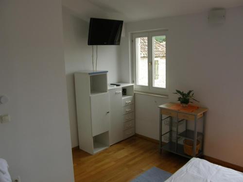 sypialnia z białą szafką i oknem w obiekcie Apartments Jakova Dudana 10 w Makarskiej
