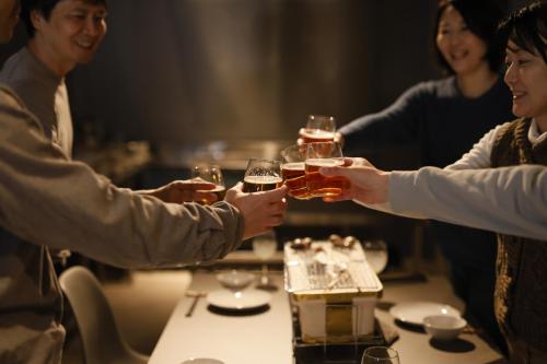 a group of people holding up glasses of beer at RITO SAKAPORT サウナ付き一棟貸しVilla in Tsushima