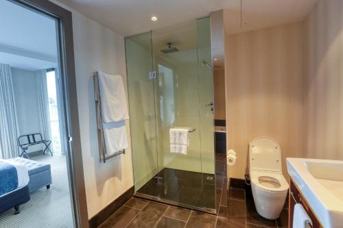 a bathroom with a shower and a toilet and a sink at Marsden Viaduct in Auckland