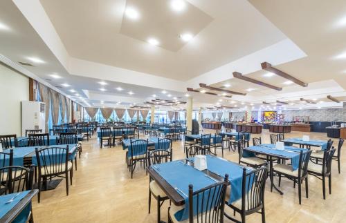 a dining room with blue tables and chairs at Senza Sunset Beach Hotel in Alanya