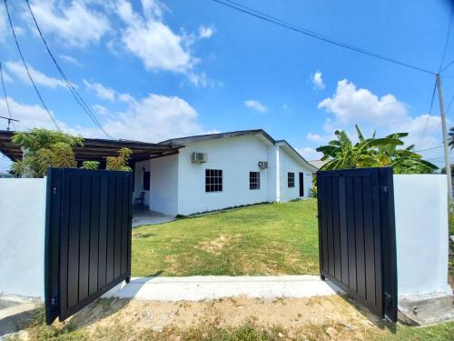 a gate in front of a white house at Perhentian Besut Homestay in Kuala Besut