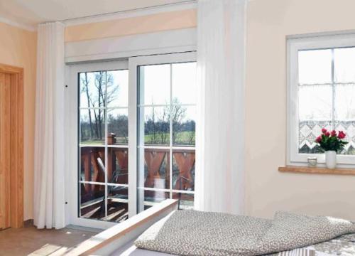 a bedroom with a bed and a sliding glass door at Gasthaus Bukoitza in Radensdorf