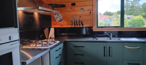 a kitchen with a stove top oven next to a window at Murrells Manapouri Lookout in Manapouri