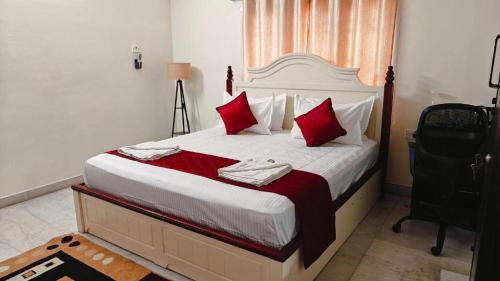 Un dormitorio con una cama grande con almohadas rojas. en Ananya service apartments, en Chennai
