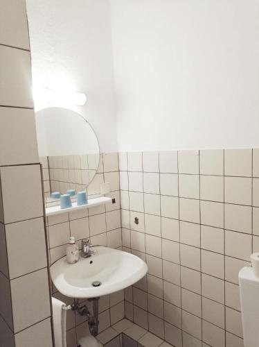 a white bathroom with a sink and a mirror at Pension Sonnenhof in Braunlage