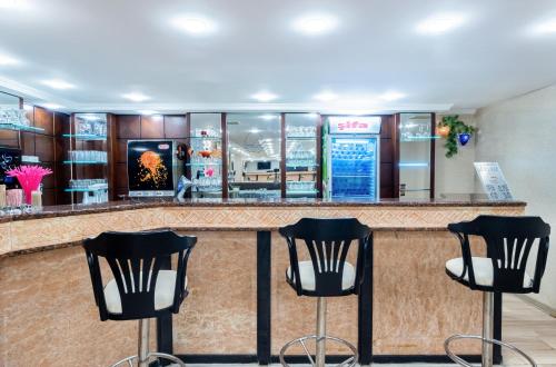 a bar with black chairs in front of it at Senza Sunset Beach Hotel in Alanya