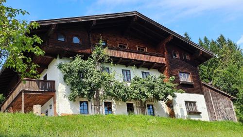 una gran casa de madera en la cima de una colina en Pfleger Ranch am Schönegg Gut, en Bischofshofen