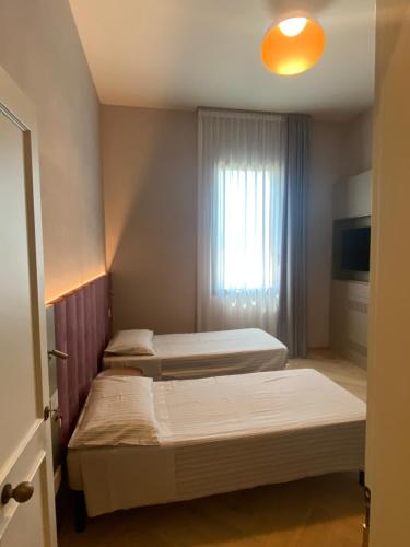 two beds in a room with a window at Villino Bavassano - Dimora Storica in Rimini