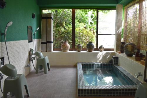 a bathroom with a tub in the middle of a room at Atami Southern Wind　 熱海 南風楼(温泉付) in Atami