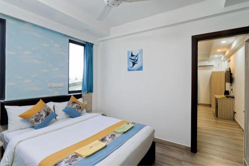 a bedroom with a large white bed with blue pillows at h78 Iru in Hulhumale