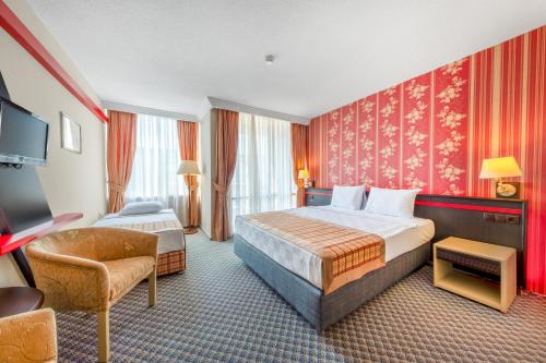 a hotel room with a bed and a chair at Senza Sunset Beach Hotel in Alanya