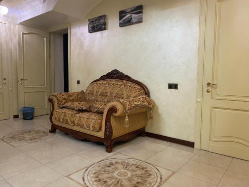 a couch sitting in a room with a wall at Bortnichi House in Kyiv