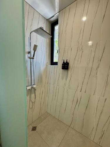a bathroom with a shower with white marble walls at MARCO Hotel in Goris